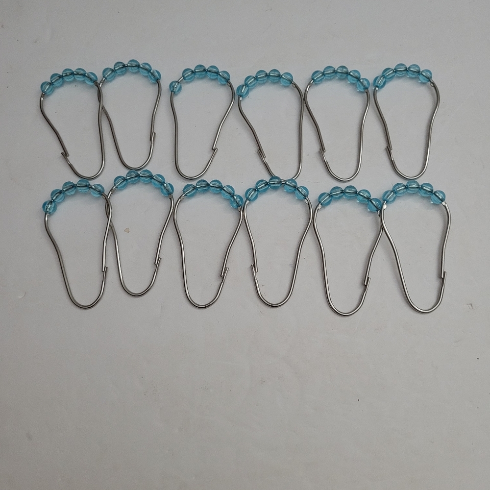 Twelve shower curtain hooks. 312